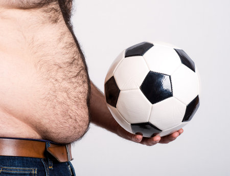 portly belly of a man with black and white footballの写真素材