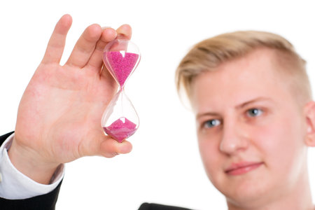portrait of a young business man in black suit with hourglassの写真素材