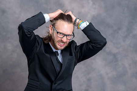 portrait of a young stressed business man in black suitの写真素材