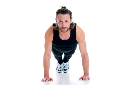 young man doing press-up in front of white background