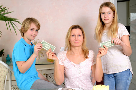 blond mother giving her children pocket moneyの写真素材