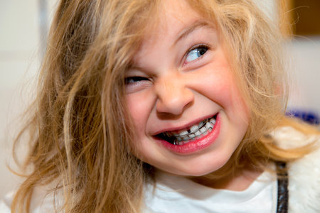 little funny girl with retainer looking in to the camera