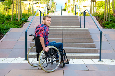 young disabled man in wheelchair in front of stairsの写真素材