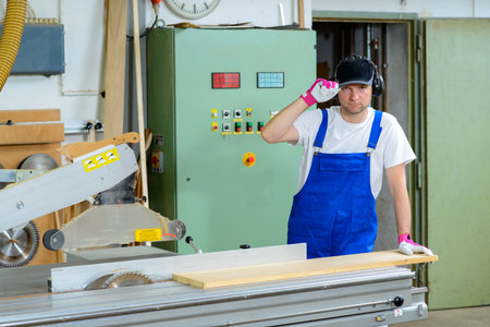 worker in a carpenter's workshop using saw machineの写真素材