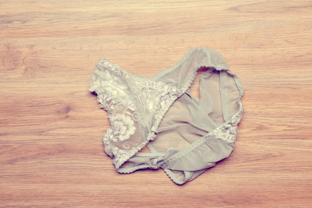 womans panties lying disheveled on wooden floorの写真素材