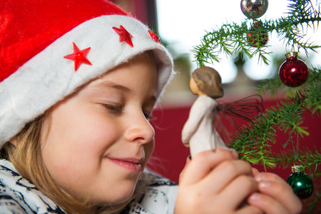 nice girl with Santa- cap and wooden angelの写真素材