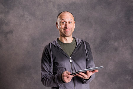 young man using tablet computer in front of gray background