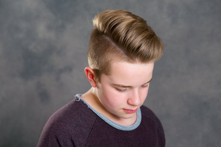 teenager in brown sweatshirt looking sadの写真素材