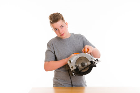 teenager in professional training using circular hand saw  in front of white backgroundの写真素材