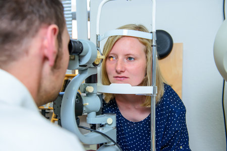 ophthalmologist checking eyes of woman for new glassesの写真素材
