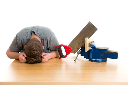 listless teenager in professional training using hand sawの写真素材