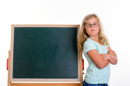 funny blond girl with round glasses and blackboard in front of white backgroundの写真素材