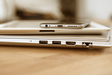 pile of different computers and phone on tableの写真素材