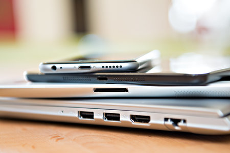 pile of different computers and phone on tableの写真素材