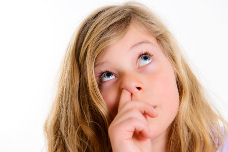 funny girl picking in nose in front of white backgroundの写真素材