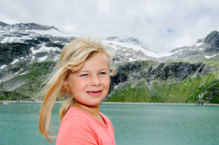 girl in front of glacial lake and high mountainsの写真素材