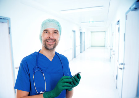 Young doctor with stethoscope in front of hospital backgroundの写真素材