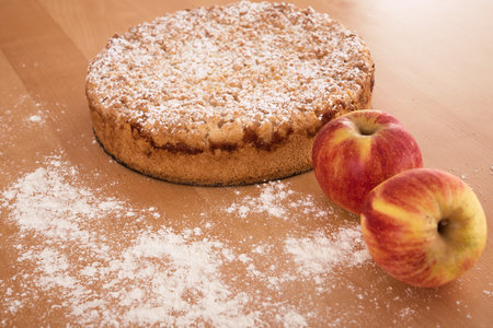 Round apple pie with crumbles on wooden groundの写真素材