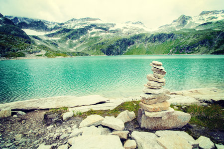 alps landscape  glacial lake in front of mountains and blue skyの写真素材