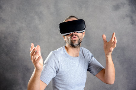 young man with virtual reality glasses looking surprisedの写真素材