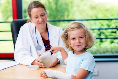 female pediatrician in white lab coat has candys for a little girlの写真素材