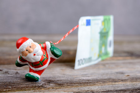 Little Santa Claus pulling big euro banknoteの写真素材
