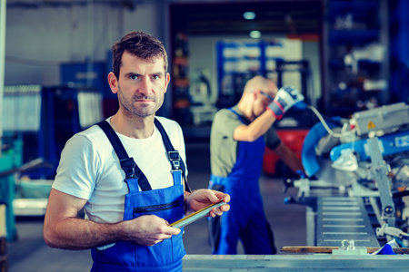two worker in factory on work benchの写真素材