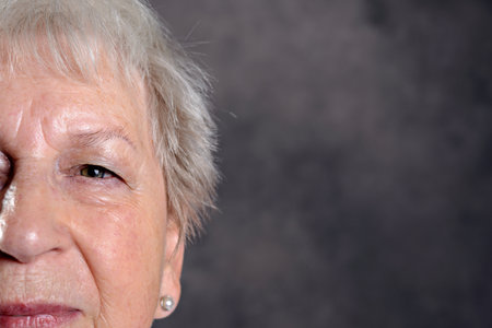 Close up portrait of elderly woman in front of dark backgroundの写真素材