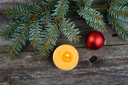 Christmas sill with fir branch and candle on wooden groundの写真素材