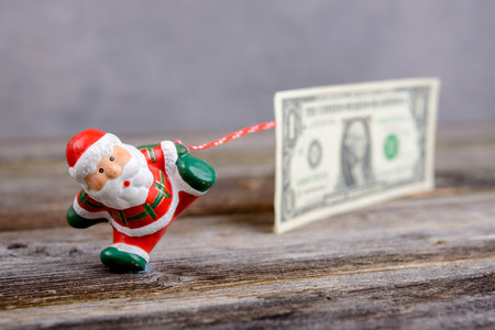 Little Santa Claus pulling big euro banknoteの写真素材