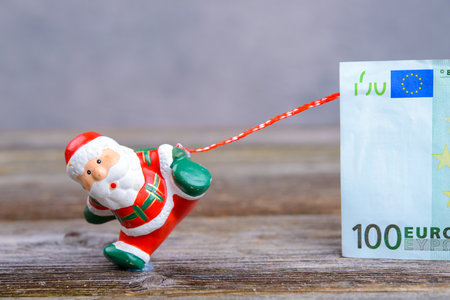little Santa Claus pulling big euro banknoteの写真素材
