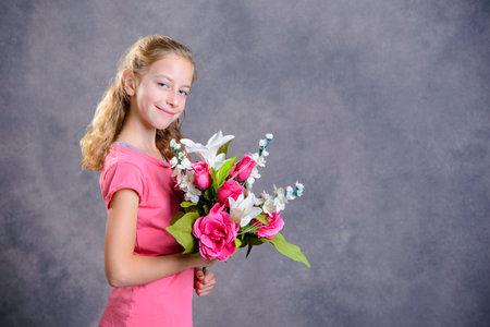 nice blond girl bouquet of flowers  in front of gray backgroundの写真素材