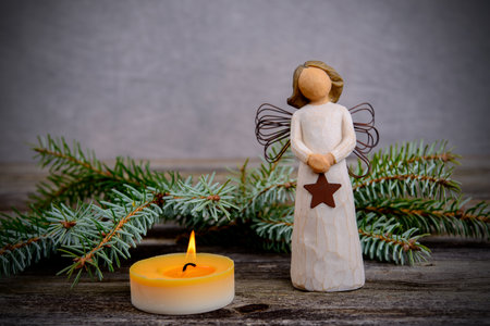 christmas sill with angel,fir branch and candle on wooden groundの写真素材