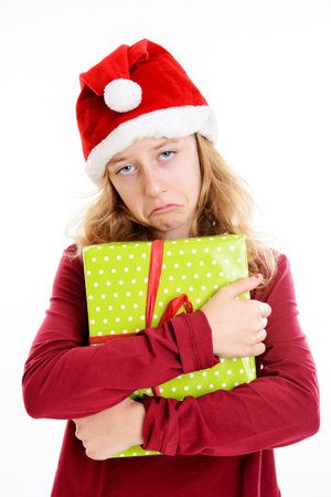 blond girl with Santa- cap is not happy with presentの写真素材