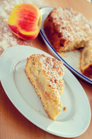 piece of apple pie with crumbles on wooden groundの写真素材