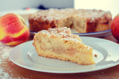 piece of apple pie with crumbles on wooden groundの写真素材