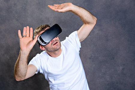 young man with virtual reality glasses looking surprisedの写真素材