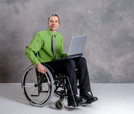 disabled business man in wheelchair working with computerの写真素材