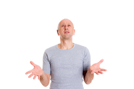 young baldheaded with open hands  man in front of white background looking surprisedの写真素材