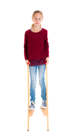 nice girl with blond hair on stilts in front of white backgroundの写真素材