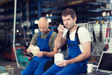 two worker in factory have a break on work benchの写真素材