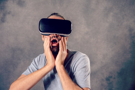 young man with virtual reality glasses looking surprisedの写真素材
