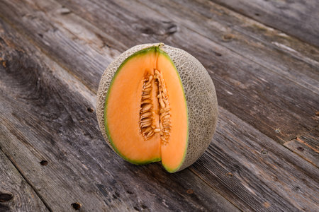 fresh sweet cantaloupe melon on wooden groundの写真素材