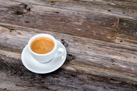 cup of coffee on wooden table from aboveの写真素材