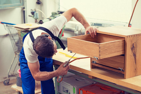 worker in blue dungarees in a carpenter's workshopの写真素材