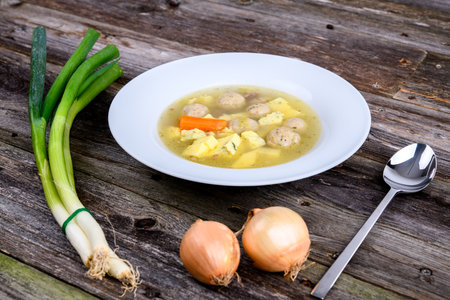 marrow balls soup in white plate with onion on wooden groundの写真素材