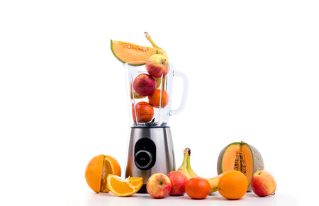 blender with a lot of fruits in front of white backgroundの写真素材
