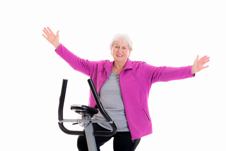 happy gray-haired female senior train with fitness machineの写真素材