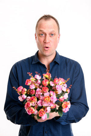 young man with bunch of flowers in front of white backgroundの写真素材