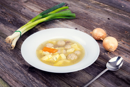 marrow balls soup in white plate with onion on wooden groundの写真素材